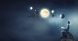 Young man with book exploring planets of sun system