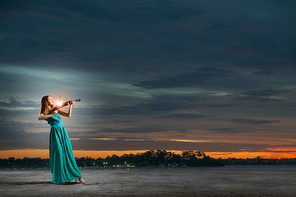 Virtuoso violin female player in green dress