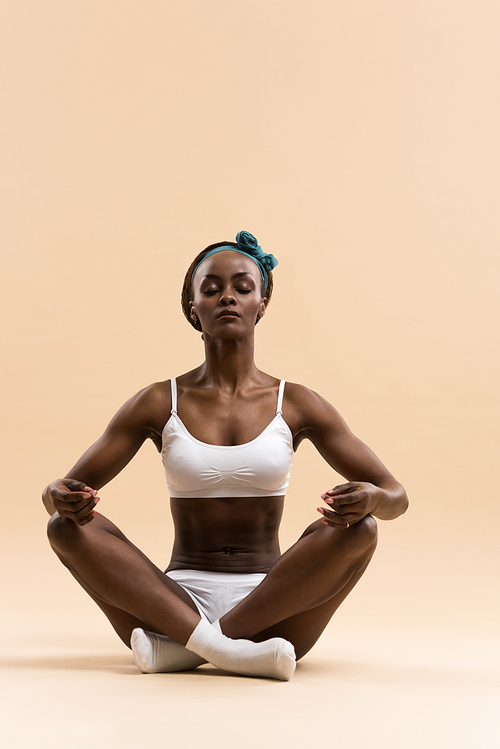 Young African woman in the lotus meditation position doing yoga