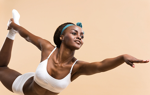 Young African woman in the stretching yoga position