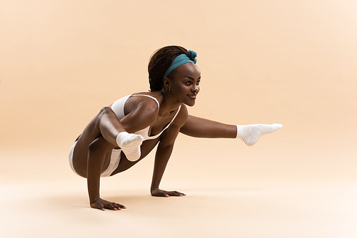 Young African woman doing yoga in stretching position