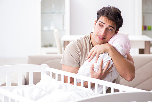 Young father enjoying time with newborn baby at home