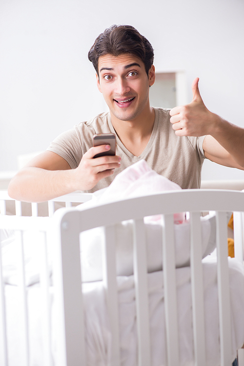 Young father enjoying time with newborn baby at home