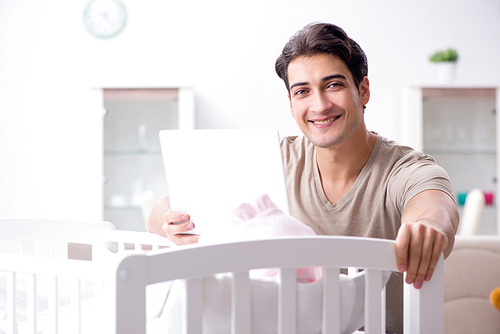 Young dad student preparing for exams and looking after baby