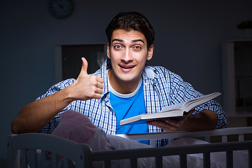 Young student doing homework and looking after newborn baby