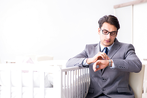 Young businessman trying to work from home caring after newborn baby