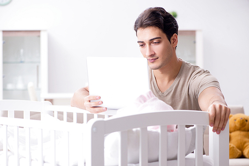 Young dad student preparing for exams and looking after baby