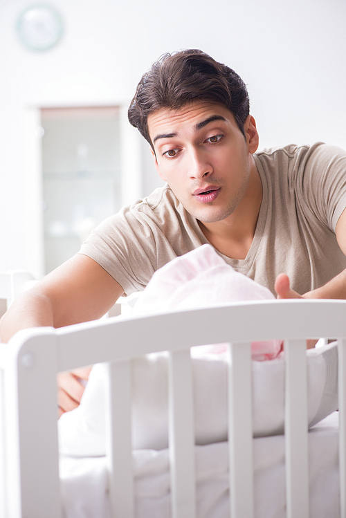 Young father enjoying time with newborn baby at home