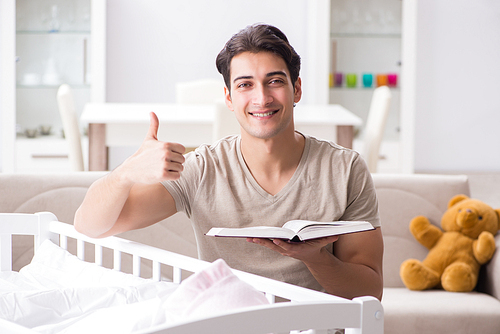 Young dad student preparing for exams and looking after baby