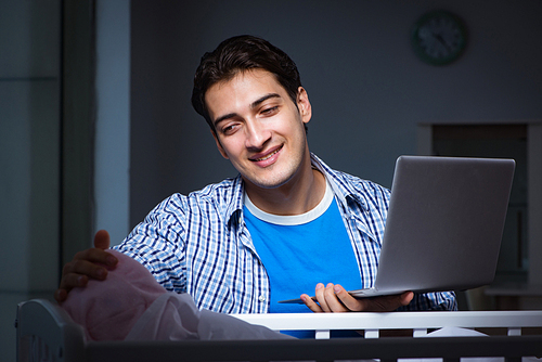 Young student doing homework and looking after newborn baby