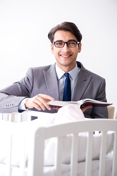 Young businessman trying to work from home caring after newborn baby