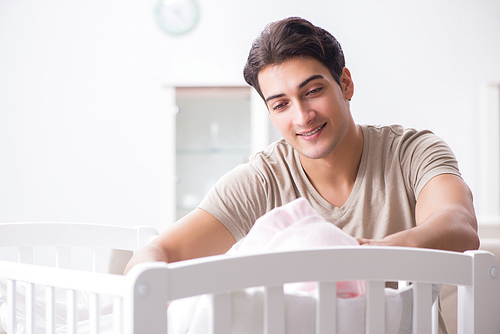 Young father enjoying time with newborn baby at home