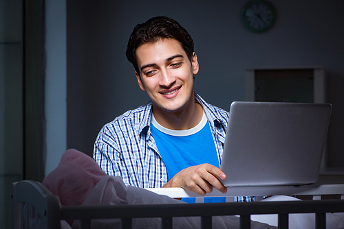 Young student doing homework and looking after newborn baby