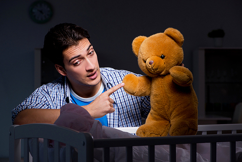 Happy dad looking after newborn baby at night