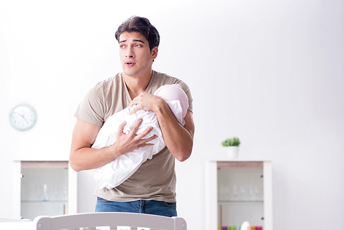 Young father enjoying time with newborn baby at home