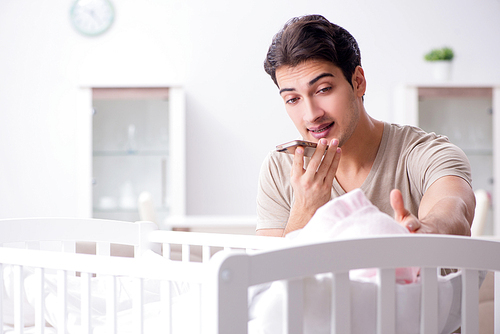Young father enjoying time with newborn baby at home