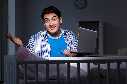 Young student doing homework and looking after newborn baby