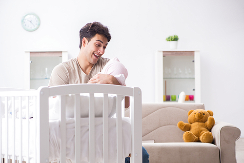 Young father enjoying time with newborn baby at home