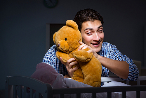 Happy dad looking after newborn baby at night