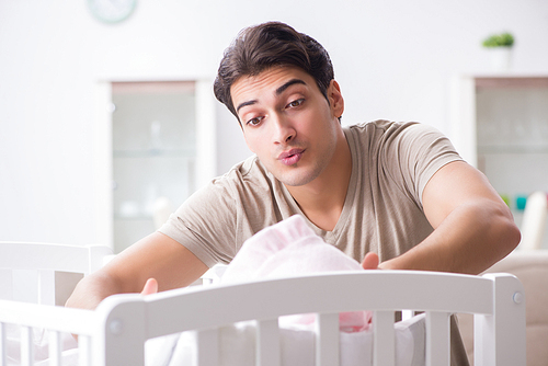 Young father enjoying time with newborn baby at home