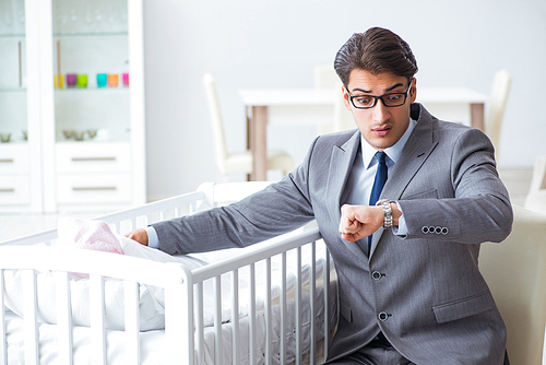 Young businessman trying to work from home caring after newborn baby