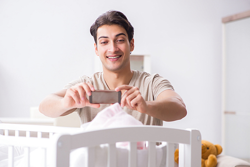 Young father enjoying time with newborn baby at home