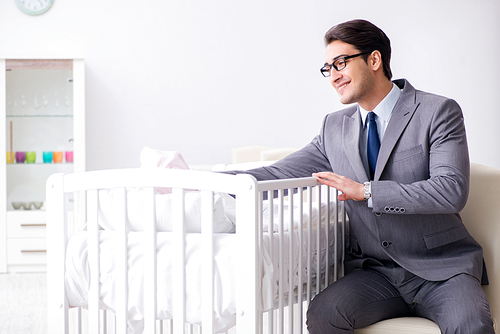 Young businessman trying to work from home caring after newborn baby