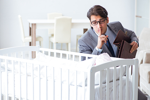 Young businessman trying to work from home caring after newborn baby