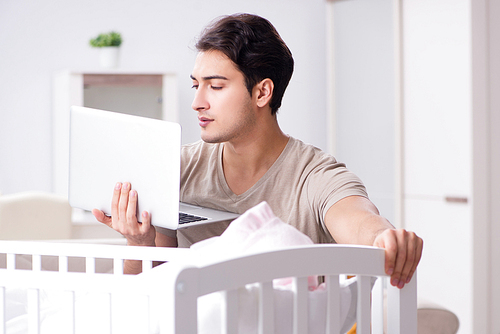 Young dad student preparing for exams and looking after baby