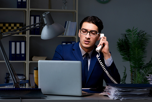 Businessman working late at night in office for overtime bonus