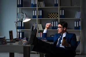 Employee working late and drinking strong coffee to stay awake