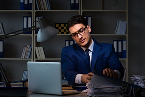 Businessman working late at night in office for overtime bonus