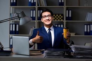 Employee working late and drinking strong coffee to stay awake