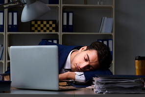 Businessman tired and sleeping in the office after overtime hours