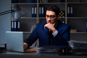 Businessman working late at night in office for overtime bonus