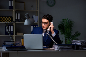 Businessman working late at night in office for overtime bonus