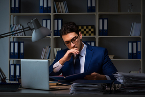 Businessman working late at night in office for overtime bonus