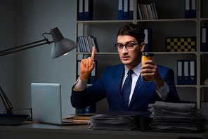 Employee working late and drinking strong coffee to stay awake