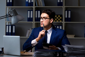 Businessman working late at night in office for overtime bonus