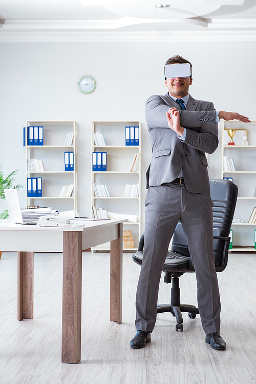 Businessman exercising in office wearing VR glasses