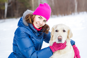 Girl with labrador dog on walk in winter park