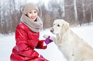 Girl with labrador dog on walk in winter park