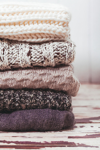 Stack warm knitted sweaters in white and gray shades