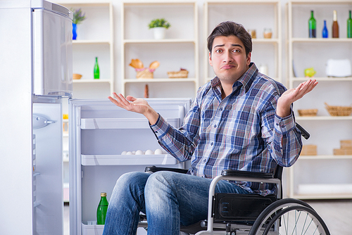 Young disabled injured man opening the fridge door