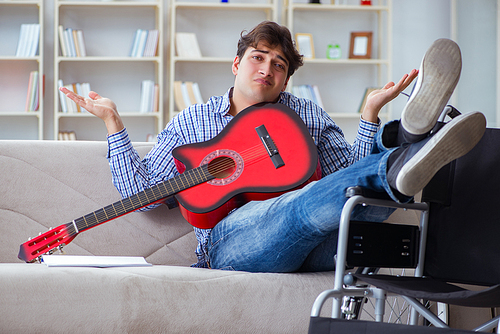 Disabled man playing guitar at home