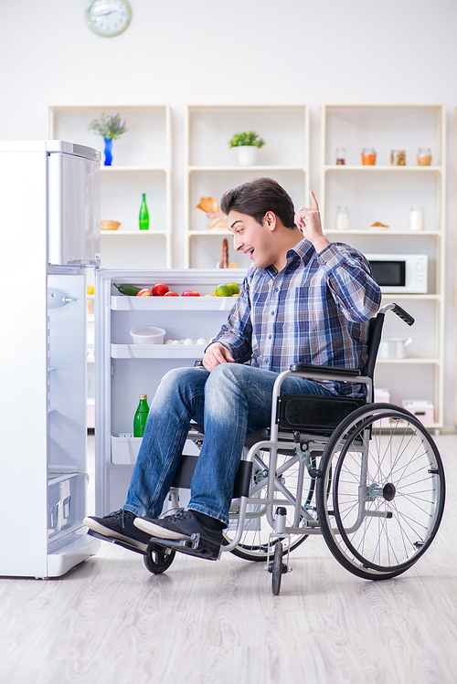 Young disabled injured man opening the fridge door