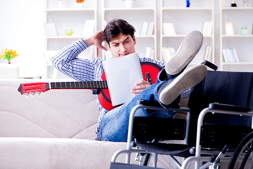 Disabled man playing guitar at home