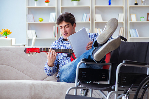 Disabled man playing guitar at home