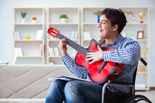 Disabled man playing guitar at home