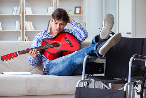 Disabled man playing guitar at home